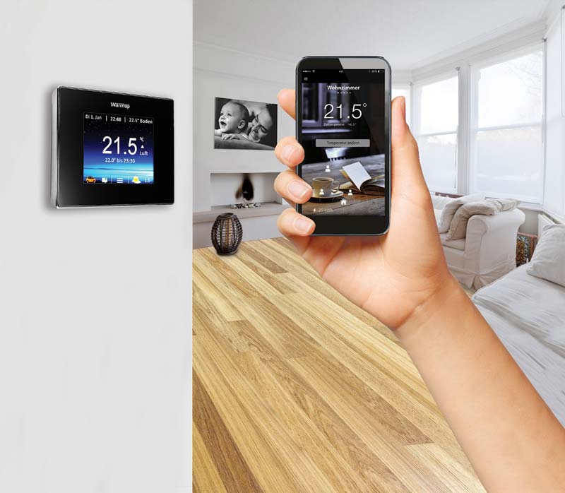 Wohnzimmer mit Smart Thermostat und Hand mit App
